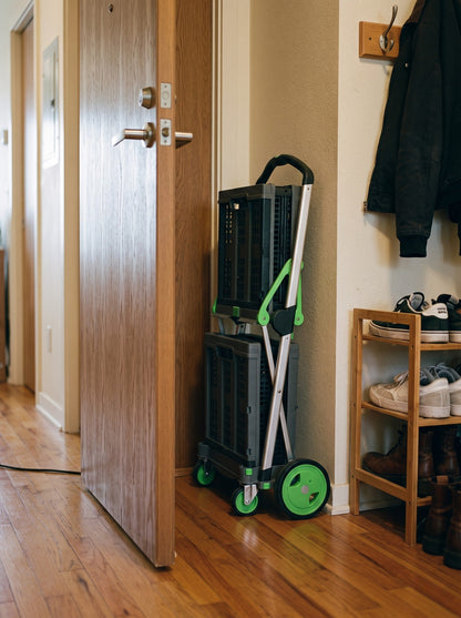 EasyRoll trolley folded to 7 inches, standing behind an apartment door
